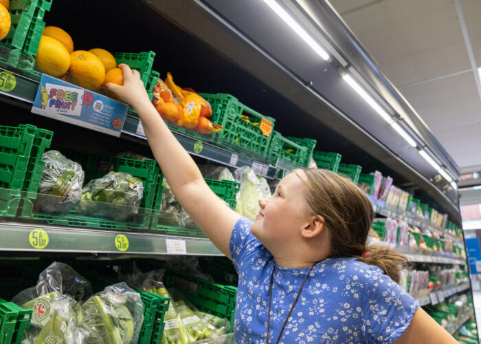 Olivia reaching for an orange instore