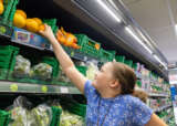 Olivia reaching for an orange instore