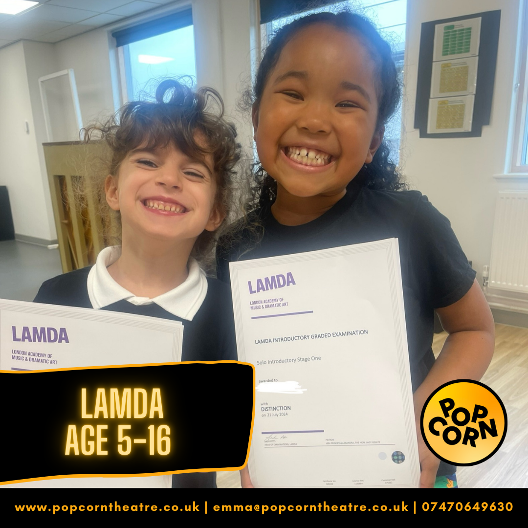 2 young girls smiling while holding their LAMDA Certificates