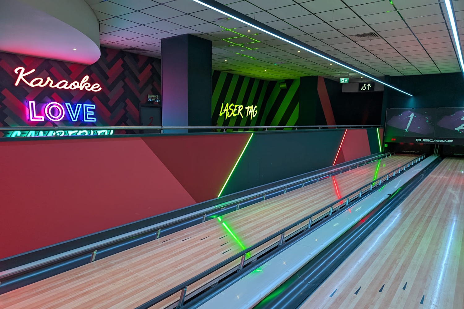 a view of neon lights with Karaoke and lasertag in the distance behind the bowling alley