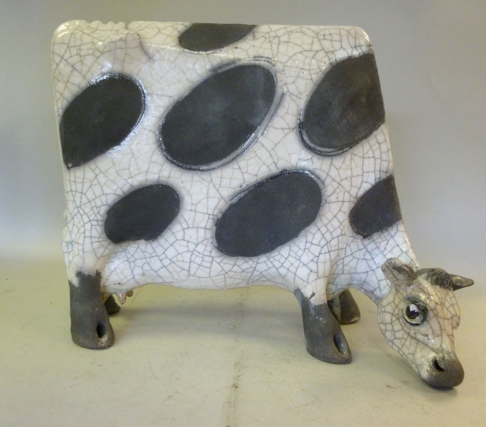 A Lawson E Rudge, raku pottery model `Flat Cow` decorated in black and