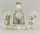 A famille verte biscuit porcelain Dignitary,  c.1680, holding a hu, and wearing a robe of complex