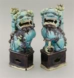 A pair of enamelled biscuit Buddhist Lion Incense-Stick Holders,  Kangxi, c.1700, each on its