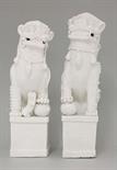 Two Dehua blanc de Chine seated Buddhist Lions,  Kangxi (1662-1722), one with a paw resting on a