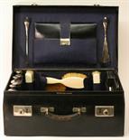 A GEORGE V LEATHER LADIES TRAVELLING CASE^ the internal compartments containing silver topped