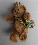 A miniature Schuco teddy bear for British Petroleum, wearing a crown and a cord with a BP button,