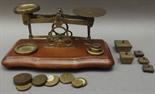 A small brass balance by T.J. Smith Son & Co. London with four nesting weights, together with a