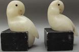 A pair of alabaster and soapstone bookends carved as white parrots with blue glass inset eyes,