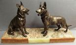 Two Art Deco sculptures, both with two silvered spelter Alsatian dogs.

.