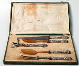 A French carving and serving set with filled silver handles, the set includes a lamb bone holder.