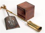 A tea caddy and two brass fire implements.