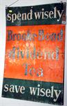 A printed 'Brooke Bond Dividend Tea' metal sign bearing the slogan 'spend wisely', 75 x 49.5cm,