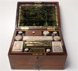 A Victorian rosewood veneered toilet case with a hinged lid opening on to a removable tray with