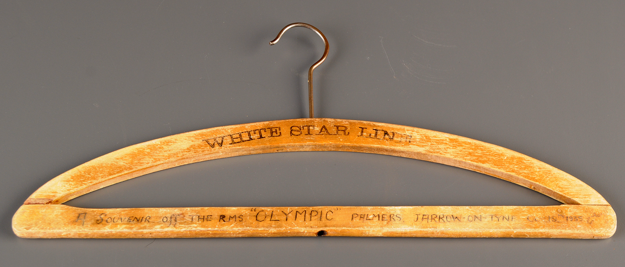 A wooden coathanger, with printed 'White Star Line' and written 'A