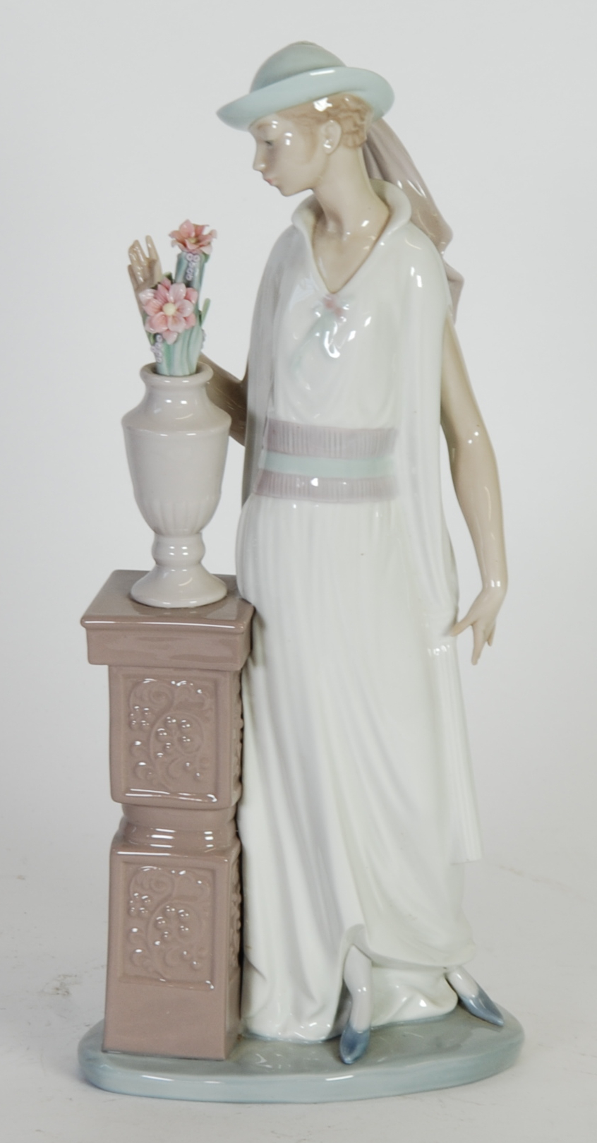 LLADRO PORCELAIN FIGURE OF A LADY STANDING BESIDE A VASE OF FLOWERS ON