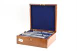 A part-set of Standard Apothecaries Measures, six out of seven, in mahogany case with brass label `
