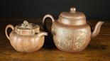 Two Large Yixing Earthenware Teapots.  One having a globular body decorated with panels of cedar,