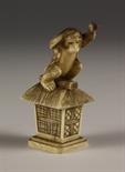 A Small Japanese Ivory Carving of a Monkey sat on a thatched pedestal, 2¾ ins (7 cms) in height.