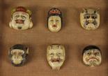 A Set of Six Japanese Carved Ivory Face Mask Buttons, fitted in a presentation case marked Yamoto