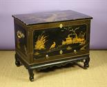 An 18th Century Chinese Lacquered Chest.  The box section having a lift-up lid decorated in raised