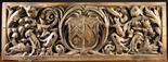 A Large 17th Century Double-sided Oak Panel richly carved with an armorial shield flanked by