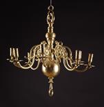 A Late 18th Century Brass Eight Branch Chandelier.  The crested S-scroll arms morticed and pegged