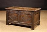 A 17th Century Oak Coffer.  The triple panel lid in a channel moulded frame on iron staple hinges,