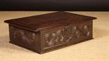 A 17th Century Boarded Oak Desk Box carved with foliated S-scrolls defined against a matted