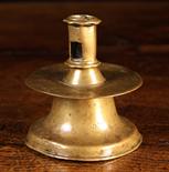 A 16th Century Brass Capstan Candlestick. The candle socket with  lateral cut ejector holes and