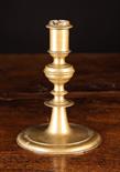 A 17th Century Bronze Candlestick.  The candle cup on integral knopped stem and flat round foot