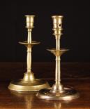 Two Similar Late 16th Century Brass Candlesticks with mid stem drip trays and flat circular bases,