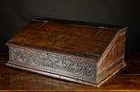 A 17th Century Boarded Oak Desk Box.  The sloped front on iron strap hinges, decorated with bands of