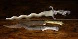 Three Antique Daggers: A serpentine bladed dagger; the handle cast in the form of a bird-headed lion