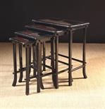 A Quartetto Nest of Lacquered Oriental Tables (A/F). The graduated rectangular tops with metal inlay