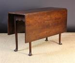 An 18th Century Cherry-wood Drop Leaf Table.  The rectangular top with two flaps standing on four