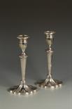 A PAIR OF CANDLESTICKS with fluted oval columns and pull-off oval scones, with shaped oval cast