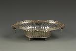 AN EDWARDIAN DISH of oval form, a pierced wavy gallery, rams head and ring handles, pierced body,