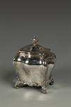 A LATE VICTORIAN TEA CADDY of bombe form, knop finial, on shell capped scroll feet, by HW,