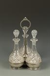 AN ELECTROPLATED DECANTER STAND, with beaded decoration, central loop carrying handle, the stands