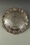 A VICTORIAN SALVER of shaped circular form, with raised scroll and shell border, presentation