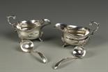 A MATCHED PAIR OF SAUCE BOATS of oval form with leaf capped flying scroll handles, on shell capped