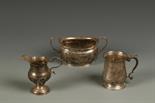 A MUG of baluster form, with a leaf cut scroll handle and spreading circular foot, bearing a