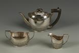 A LATE VICTORIAN THREE PIECE TEA SET of oval form, with angular handles, part fluted decoration, by