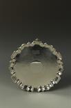 AN EDWARDIAN SALVER of shaped circular form, with a raised pie-crust border, hammered body and
