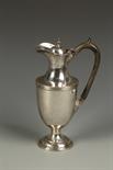 AN EDWARDIAN EWER of vase form, with a scroll handle, on a circular foot, by William Hutton and Co.