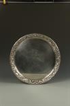 A VICTORIAN TRAY of circular form, the raised cast border with pierced decoration in the Classical