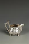 A VICTORIAN CREAM JUG of circular bellied form, with a scroll caryatid capped handle, the body