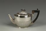 A VICTORIAN TEAPOT of oval form, with angular handle and part fluted decoration, by Charles Stewart