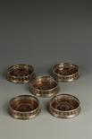 A SET OF FIVE GEORGE III COASTERS of circular form, with wood bases, crested, the bodies with