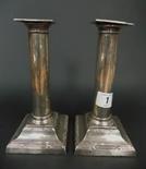 Pair of Edwardian silver column candlesticks of plain reeded form upon a square tapered loaded base,
